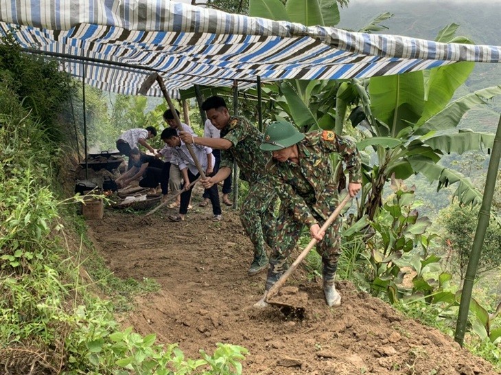 Cán bộ, chiến sĩ Đồn Biên phòng Thàng Tín san nền dựng lán tạm cho gia đình anh Ly Seo Sử. Ảnh: Đình Trọng