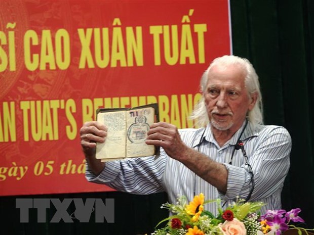 Cựu binh Mỹ Peter Mathews và cuốn nhật ký của liệt sỹ Cao Xuân Tuất trước khi trao lại cho thân nhân của liệt sỹ. (Ảnh: Phan Quân/TTXVN)