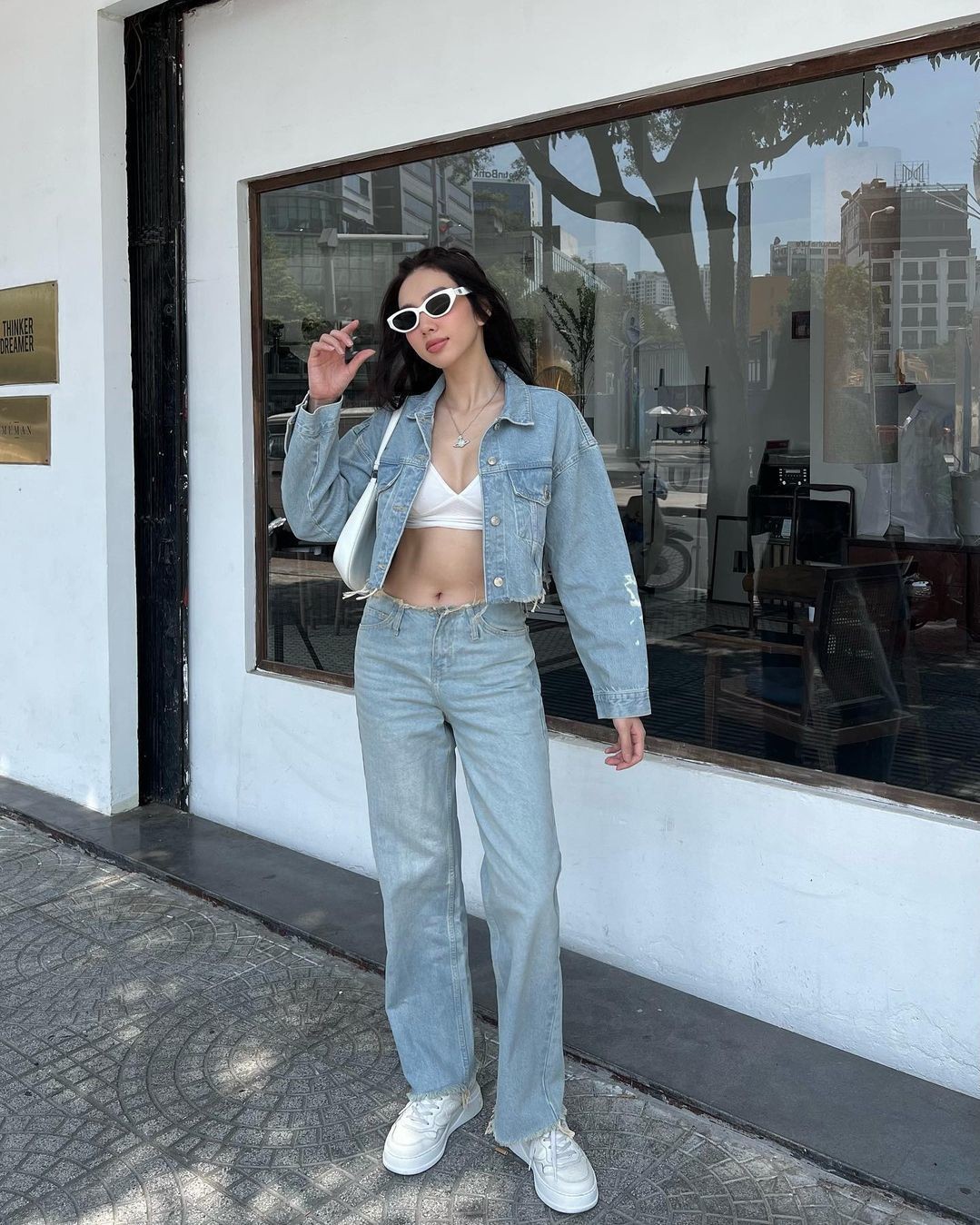 Hoa hậu Thùy Tiên mặc áo kết hợp quần jeans cạp trễ, khoe dáng khi ra phố. Trang phục làm nổi bật vòng một đầy, eo săn chắc của nàng hậu.