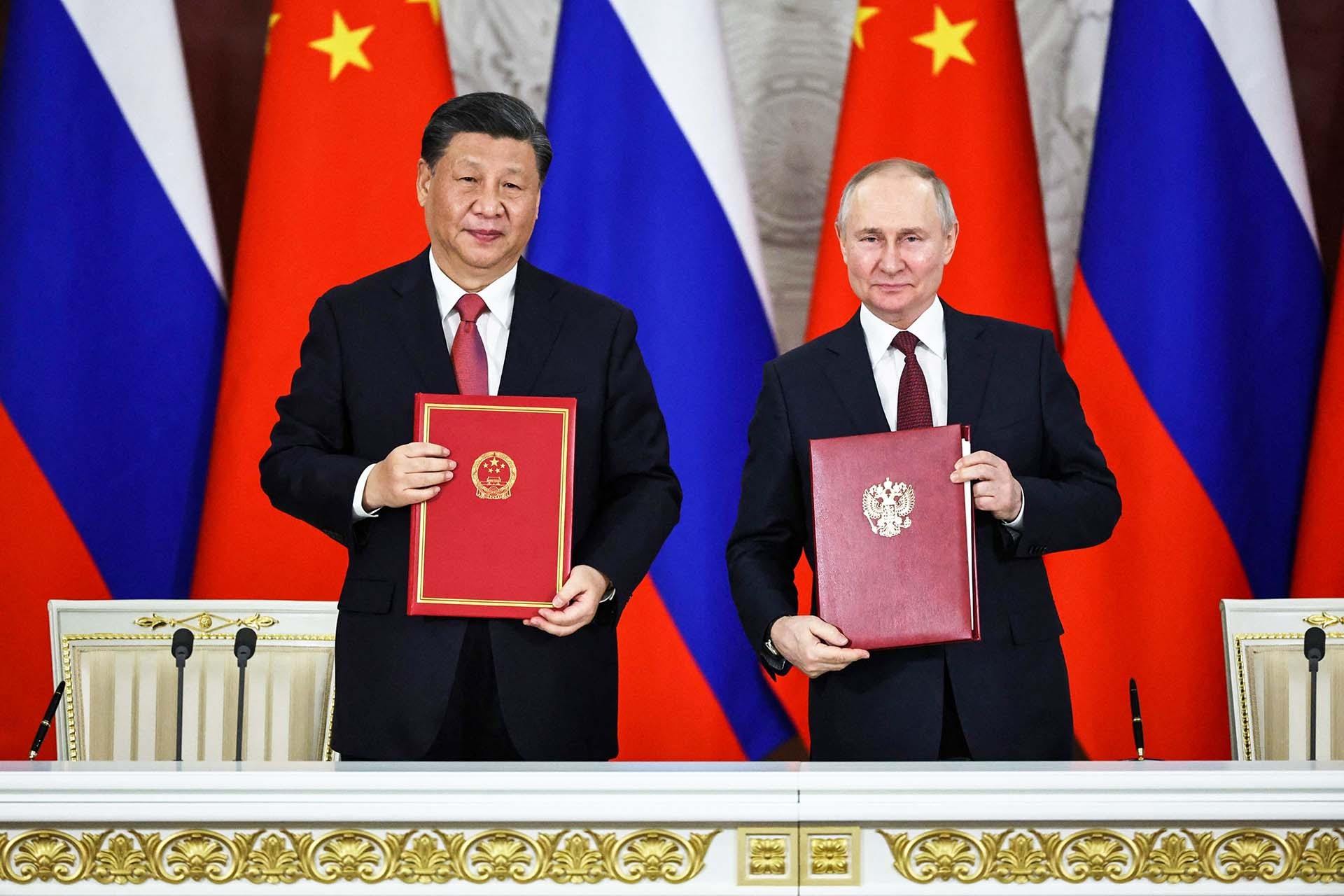 Chủ tịch Trung Quốc Tập Cận Bình (trái) và Tổng thống Nga Vladimir Putin ký kết văn bản sau hội đàm ngày 21/3 tại Moscow. (Nguồn: Getty Images) Chủ tịch Trung Quốc Tập Cận Bình (trái) và Tổng thống Nga Vladimir Putin ký kết văn bản sau hội đàm ngày 21/3 tại Moscow. (Nguồn: Getty Images)