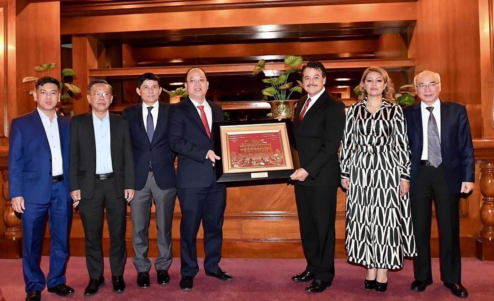 Phó Bí thư Thành ủy Nguyễn Hồ Hải trao quà lưu niệm cho Ủy viên Bộ Chính trị Đảng Lao động, Chủ nhiệm Ủy ban đối ngoại Hạ viện Mexico Alfredo Femat Bañuelos. (Nguồn: TTXVN)