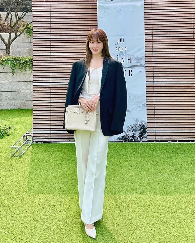 Xuất hiện trong một sự kiện gần đây, Hari Won khoe phong cách thanh lịch với 'cây' đồ kiểu công sở. Bà xã Trấn Thành phối áo kiểu và quần ống suông tạo thành set đồ white-on-white, tôn vóc dáng cao ráo. Bên ngoài, cô khoác blazer đối lập màu sắc, tạo điểm nhấn.