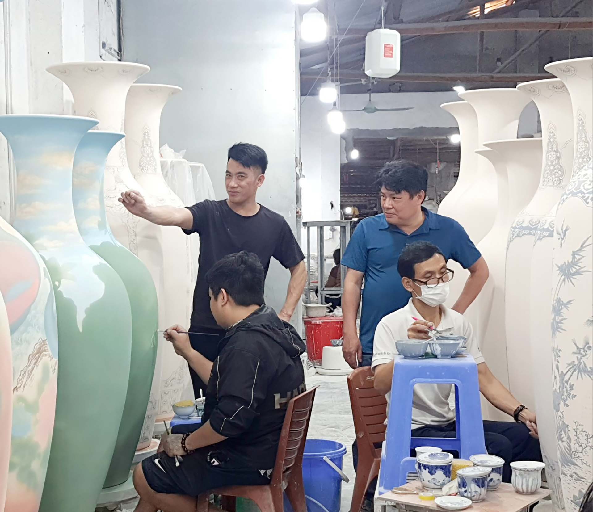 Nghệ nhân Phạm Nguyên và ông Nguyễn Văn Dũng, Bí thư chi bộ - Chủ nhiệm HTX Dịch vụ Nông nghiệp Kim Lan đang chia sẻ với các bạn trẻ về kỹ thuật làm gồm. (Ảnh: M.H)