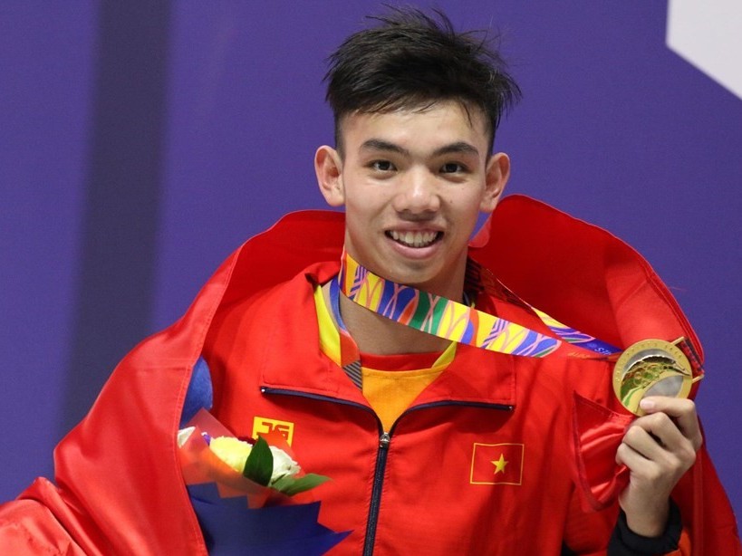 VĐV Nguyễn Huy Hoàng cầm cờ Đoàn Thể thao Việt Nam tại SEA Games 32