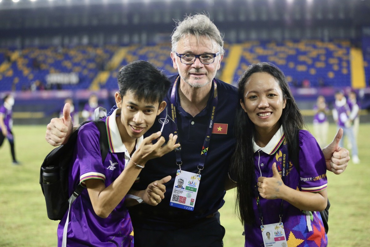 HLV Troussier chụp ảnh cùng các tình nguyện viên Campuchia sau trận đấu. HLV Troussier chụp ảnh cùng các tình nguyện viên Campuchia sau trận đấu.