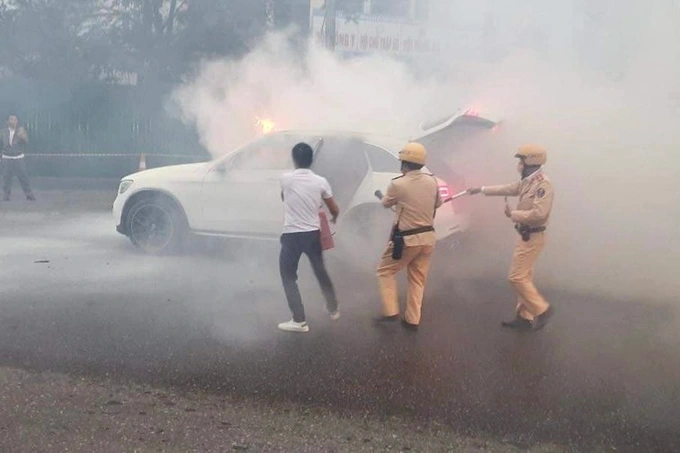 Cán bộ Đội CSGT số 6 hỗ trợ dập tắt đám cháy ô tô trên đường Phạm Hùng