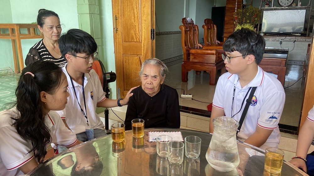 (07.28) Tuấn Khang (thứ hai từ trái sang), kiều bảo trẻ đến từ Hungary, lắng nghe câu chuyện của Mẹ Ngô Thị Mừng. (Ảnh: Hà Anh)