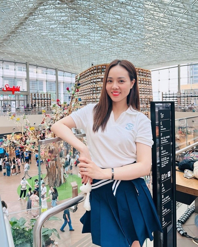 Vợ NSND Công Lý phối áo thun cổ polo cùng chân váy xếp ly tông trắng-xanh navy. Bộ cánh được cô sắm từ những brand Hàn có mức giá không quá đắt đỏ. 