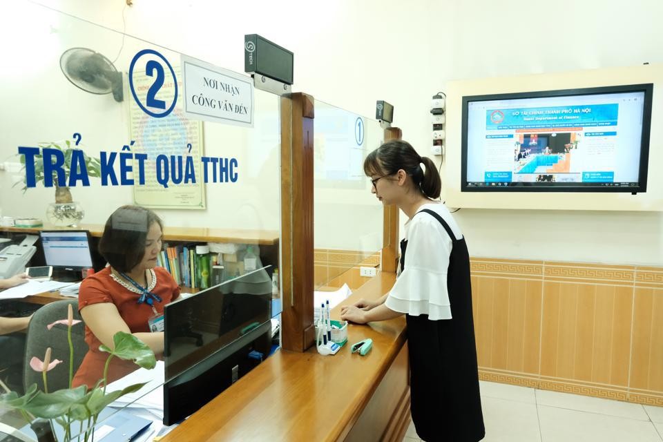 Giải quyết thủ tục hành chính cho doanh nghiệp tại Sở Tài chính Hà Nội. Ảnh: Phạm Hùng