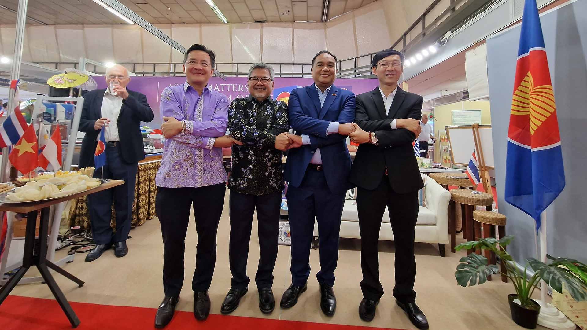 Đại sứ Nhóm ACAT bắt tay bày tỏ tinh thần đoàn kết ASEAN trước gian hàng trưng bày của ASEAN. 