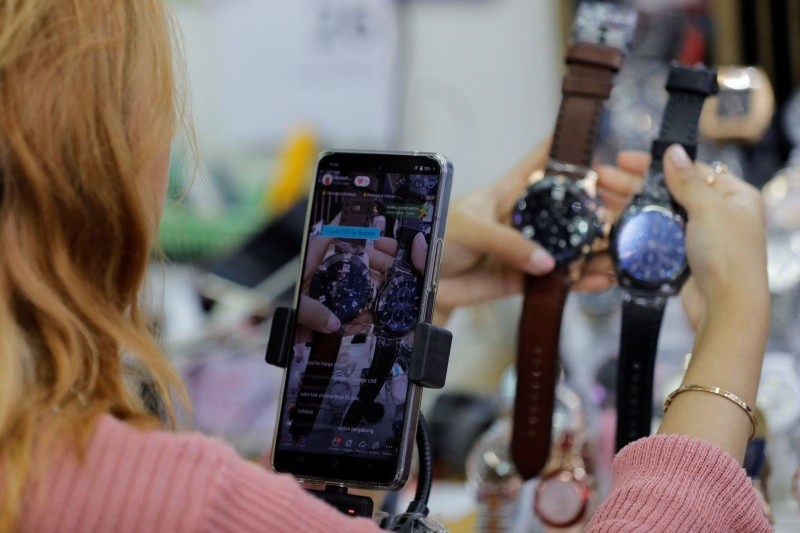 ột người bán hàng đang livestream trên mạng xã hội tại trung tâm mua sắm ICT ở Jakarta, Indonesia. ột người bán hàng đang livestream trên mạng xã hội tại trung tâm mua sắm ICT ở Jakarta, Indonesia.