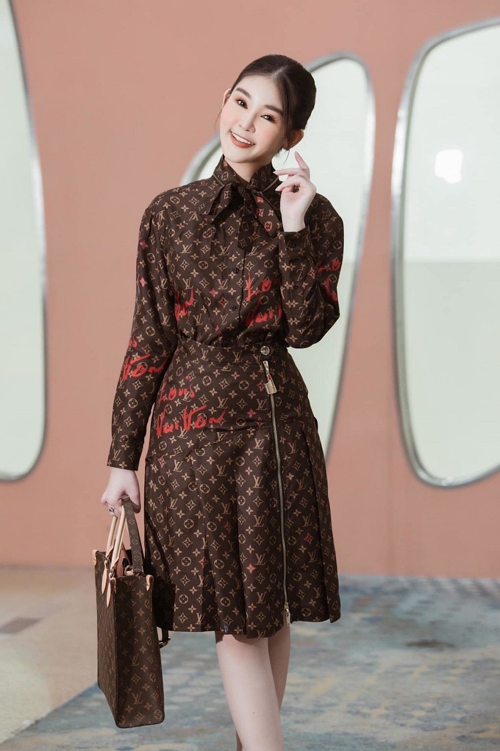 Hoa hậu kết hợp trang phục gồm sơ mi, chân váy với túi xách đồng điệu họa tiết Monogram của thương hiệu Louis Vuitton, tổng trị giá khoảng 200 triệu đồng. Hoa hậu kết hợp trang phục gồm sơ mi, chân váy với túi xách đồng điệu họa tiết Monogram của thương hiệu Louis Vuitton, tổng trị giá khoảng 200 triệu đồng.