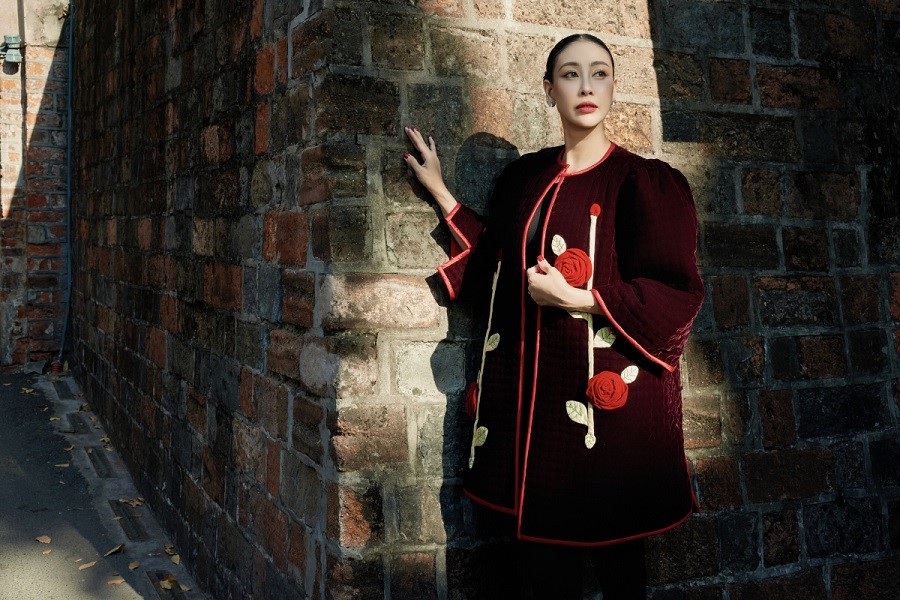 Hoa hậu Việt Nam 1992 tôn vẻ sang trọng cùng mẫu áo khoác màu đỏ đun, đính kết những bông hoa hồng 3D tôn nét duyên dáng của người mặc.