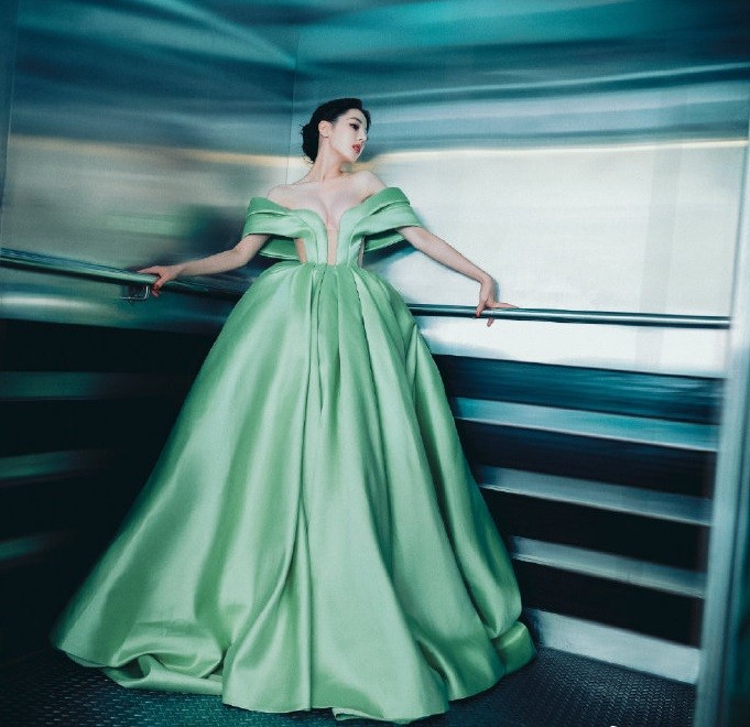 Theo Sinchew, Địch Lệ Nhiệt Ba mặc chiếc váy dạ hội liền mảnh màu xanh lá cây, thân trên xếp ly cầu kỳ và thân dưới kín đáo.