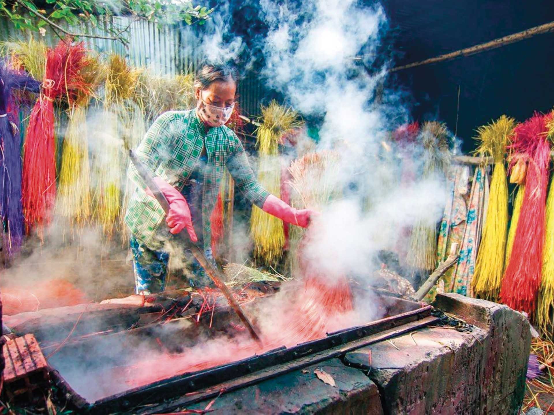 Để tạo ra sản phẩm có màu sắc, hoa văn phong phú, được người tiêu dùng ưa chuộng, lát nhuộm màu rất quan trọng của chiếu Định Yên. (Ảnh: Phương Nghi)