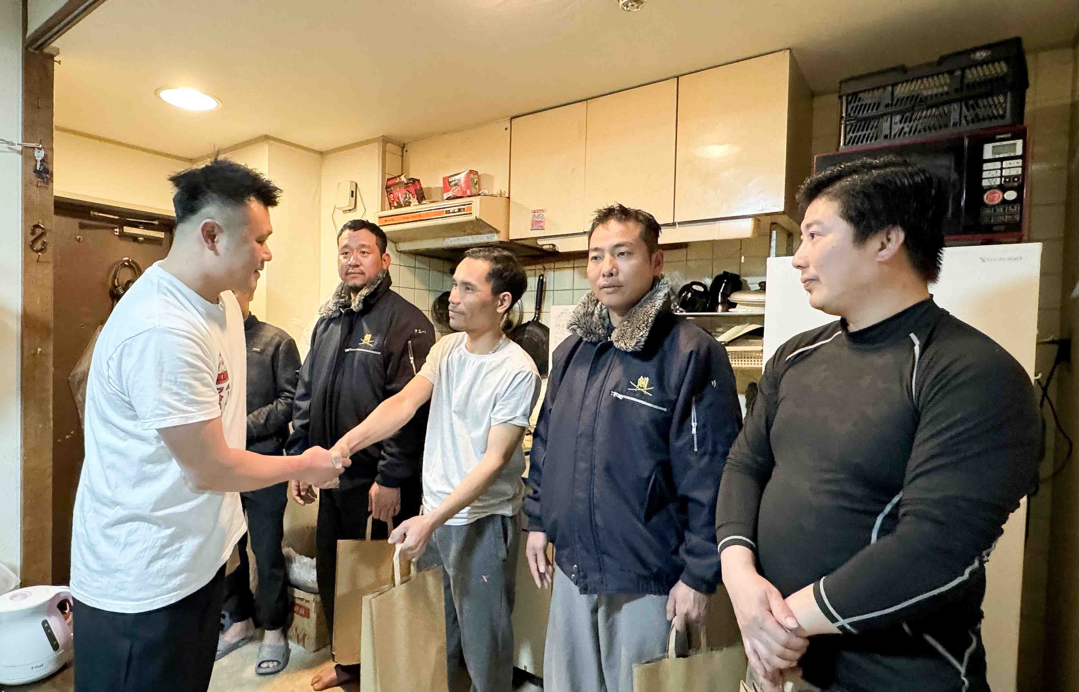 Anh Đặng Huy Quyết, chủ cửa hàng Phở Quyết, trao các phần quà Tết cho lao động Việt Nam tại Nhật. (Nguồn: TTXVN)