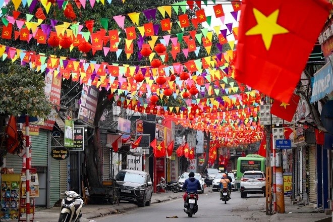 Cờ, hoa đỏ rợp cả con phố dịp Tết đến, Xuân về. (Ảnh: Minh Hiếu/Vietnam+)