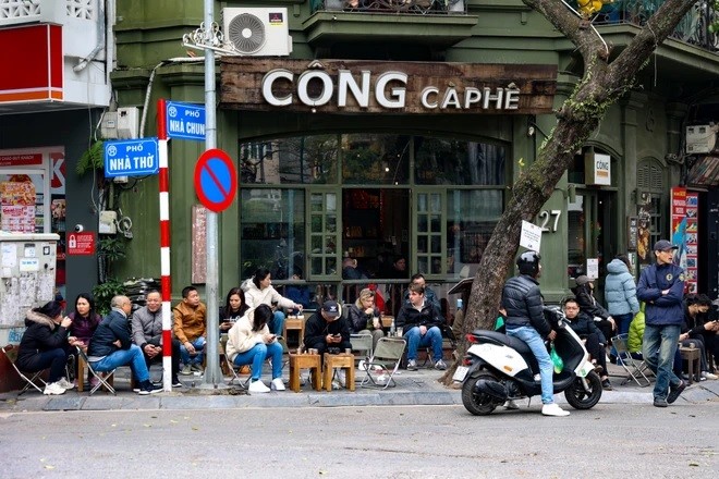 Khi đã tránh xa xô bồ của công việc, nhiều người tranh thủ nghỉ ngơi, uống càphê trong ngày 30 Tết. (Ảnh: Minh Hiếu/Vietnam+)