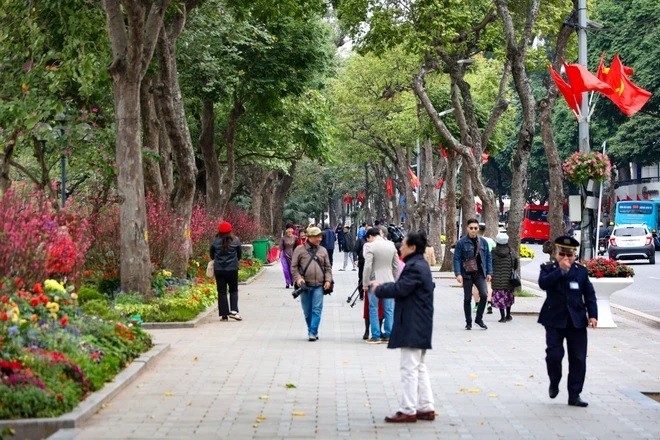 Xung quanh Hồ Hoàn Kiếm, nhiều người dân đến để tận hưởng cái lạnh cũng như không khí yên bình ngày 30 Tết. (Ảnh: Minh Hiếu/Vietnam+)