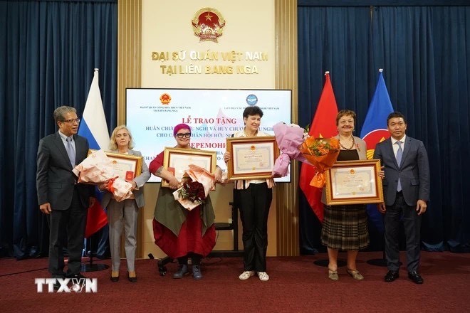  Ảnh 1: Đại sứ Đặng Minh Khôi và Chủ tịch Liên hiệp các tổ chức hữu nghị Việt Nam Phan Anh Sơn trao những huy chương cao quý. (Duy Trinh/PV TTXVN tại LB Nga)