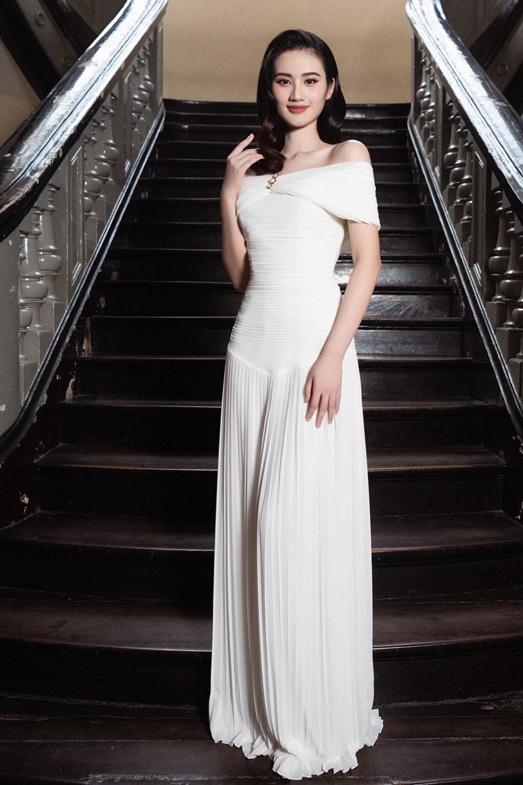 Hoa hậu Ý Nhi tham dự một sự kiện tại TP. Hồ Chí Minh với trang phục của nhà thiết kế trong nước. Chiếc đầm có kiểu dáng trễ vai, thân váy ứng dụng kỹ thuật xếp ly đan xen ngang và dọc để đứng phom nhưng vẫn có độ bay bổng.