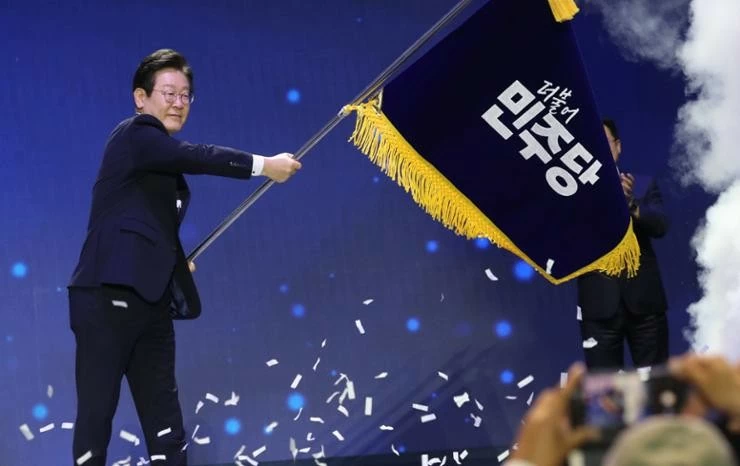 Lãnh đạo Đảng Dân chủ Lee Jae-myung vẫy cờ đảng sau khi tái đắc cử. (Nguồn: Yonhap) Lãnh đạo Đảng Dân chủ Lee Jae-myung vẫy cờ đảng sau khi tái đắc cử. (Nguồn: Yonhap)
