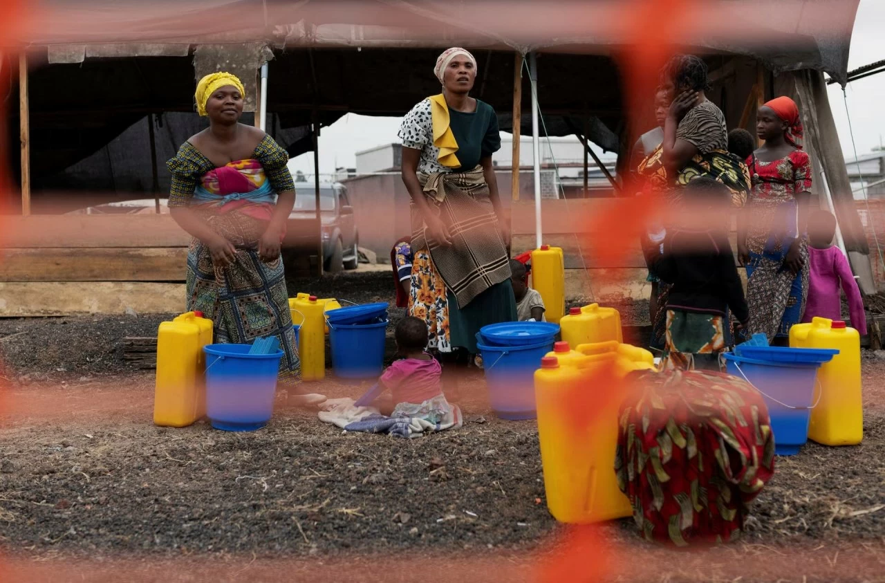 Những người phải di dời trong nước và người thân của bệnh nhân mpox tập trung sau hàng rào để rời khỏi trung tâm điều trị sau khi nhận được bộ dụng cụ vệ sinh và được thông báo về các biện pháp vệ sinh cần tuân thủ, tại trung tâm điều trị ở Munigi,