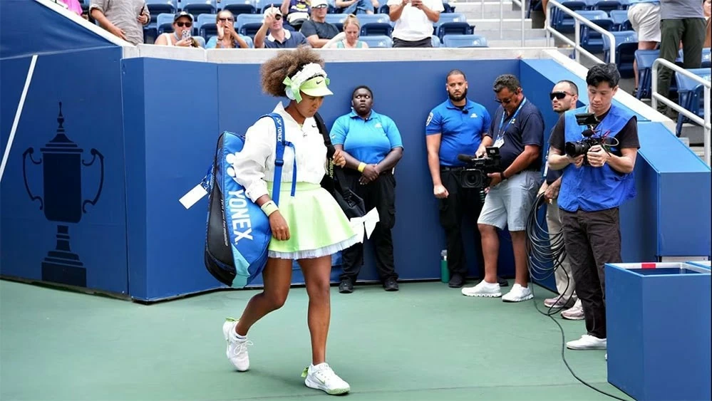 Trang phục của tay vợt gốc Nhật Naomi Osaka mang hai màu xanh neon và trắng chủ đạo cùng điểm nhấn là những chiếc nơ ở túi xách, trên headphone. (Nguồn: USTA) Trang phục của tay vợt gốc Nhật Naomi Osaka mang hai màu xanh neon và trắng chủ đạo cùng điểm nhấn là những chiếc nơ ở túi xách, trên headphone. (Nguồn: USTA)