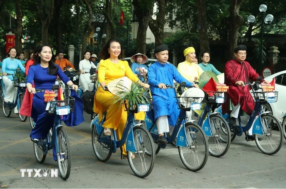 Những tà áo dài rực rỡ trên các tuyến phố Hà Nội. (Nguồn: TTXVN) Những tà áo dài rực rỡ trên các tuyến phố Hà Nội. (Nguồn: TTXVN)