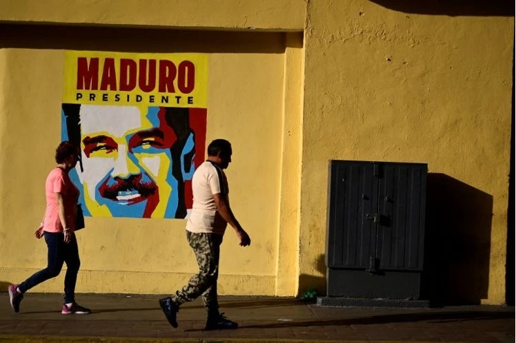 Mọi người đi ngang qua tấm áp phích mô tả Tổng thống Nicolas Maduro trong cuộc bầu cử tổng thống ở Caracas, Venezuela, ngày 28/7. (Nguồn: Reuters) Mọi người đi ngang qua tấm áp phích mô tả Tổng thống Nicolas Maduro trong cuộc bầu cử tổng thống ở Caracas, Venezuela, ngày 28/7. (Nguồn: Reuters)