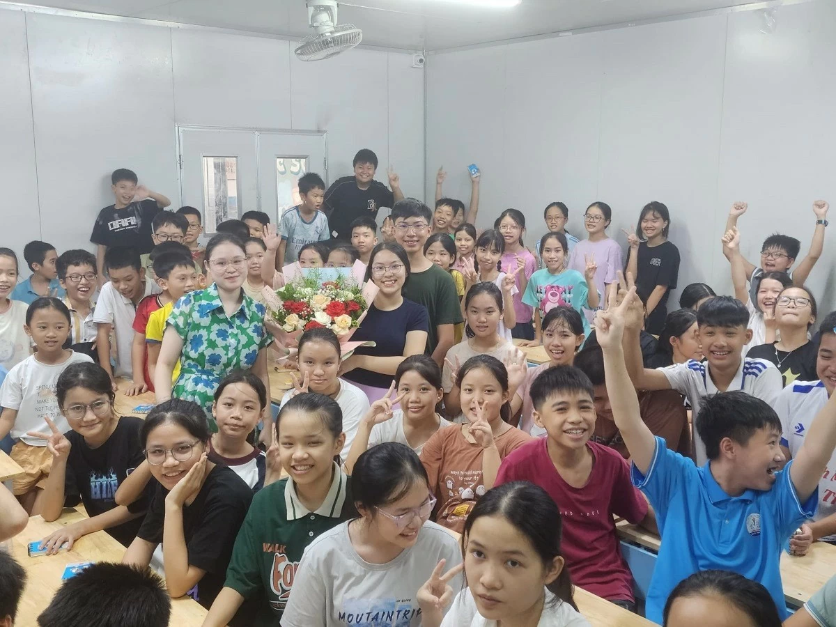 Tường Anh và Việt Bách chụp ảnh cùng các em học sinh trong buổi giao lưu Giới trẻ mang tri thức và tâm huyết phụng sự cộng đồng