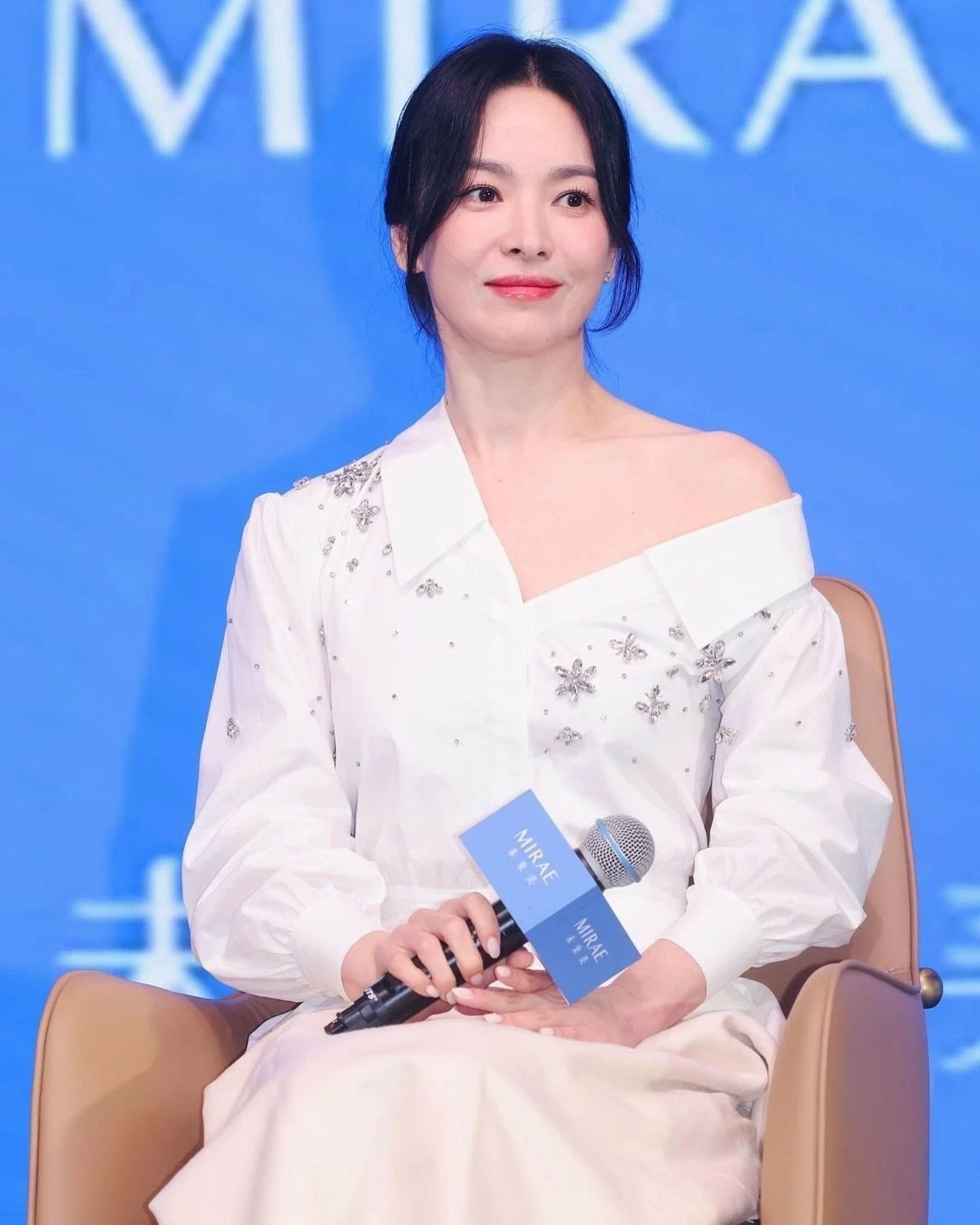 Khi xuất hiện tại sự kiện, Song Hye Kyo nhận tràng pháo tay và những lời chào mừng rộn rã từ khán phòng. Diễn viên nói với khán giả: Đầm sơ mi trắng cách điệu giúp Song Hye Kyo trẻ hơn tuổi