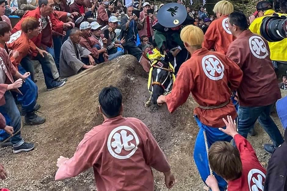 Một người đang cố gắng cưỡi ngựa leo qua một con dốc tại lễ hội Ageuma Shinji. (Nguồn: mạng xã hội X) Một người đang cố gắng cưỡi ngựa leo qua một con dốc tại lễ hội Ageuma Shinji. (Nguồn: mạng xã hội X)