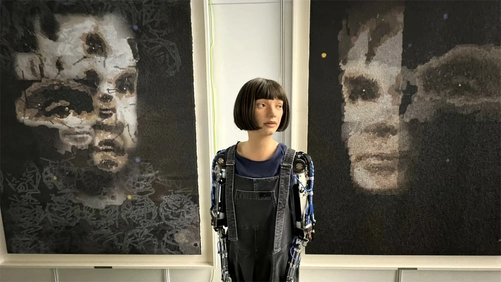Ai-Da và bức tranh “AI God. Portrait of Alan Turing (2024)” do robot AI này tạo ra chuẩn bị được đấu giá. Ảnh: Sotheby’s Ai-Da và bức tranh “AI God. Portrait of Alan Turing (2024)” do robot AI này tạo ra chuẩn bị được đấu giá. Ảnh: Sotheby’s
