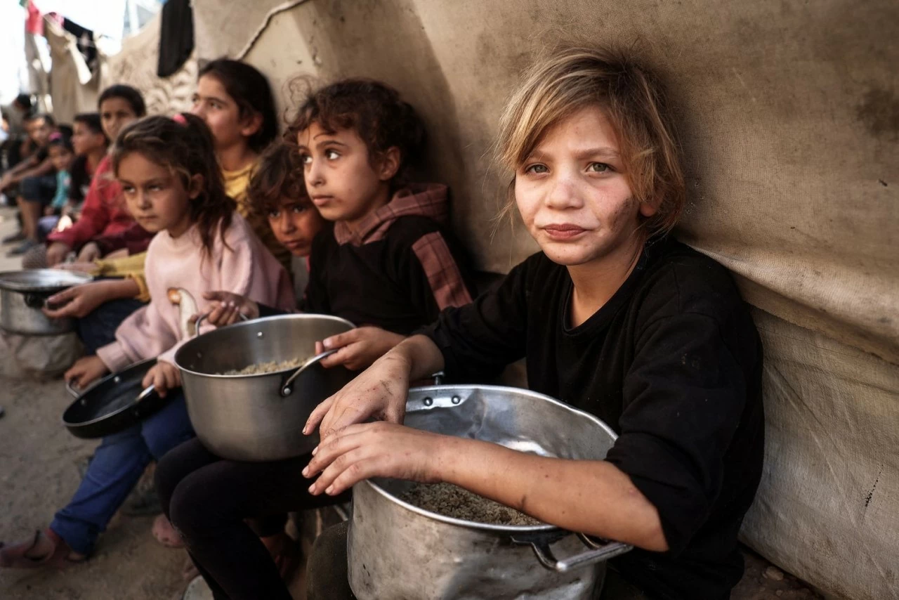 Trẻ em Palestine nhận thực phẩm tại trại tị nạn Bureij ở trung tâm Gaza, ngày 6/11. Cuộc chiến Israel-Hamas tại dải đất này kéo dài hơn 1 năm, khiến người dân nơi đây lâm vào cuộc khủng hoảng nhân đạo nghiêm trọng. (Nguồn: AFP/Getty Images) Trẻ em Palestine nhận thực phẩm tại trại tị nạn Bureij ở trung tâm Gaza, ngày 6/11. Cuộc chiến Israel-Hamas tại dải đất này kéo dài hơn 1 năm, khiến người dân nơi đây lâm vào cuộc khủng hoảng nhân đạo nghiêm trọng. (Nguồn: AFP/Getty Images)