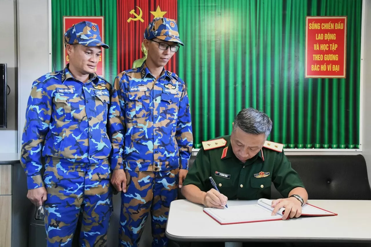 Trung tướng Lê Quang Minh ghi sổ lưu niệm tại Tàu 526. (Ảnh: Văn Định) Trung tướng Lê Quang Minh ghi sổ lưu niệm tại Tàu 526. (Ảnh: Văn Định)