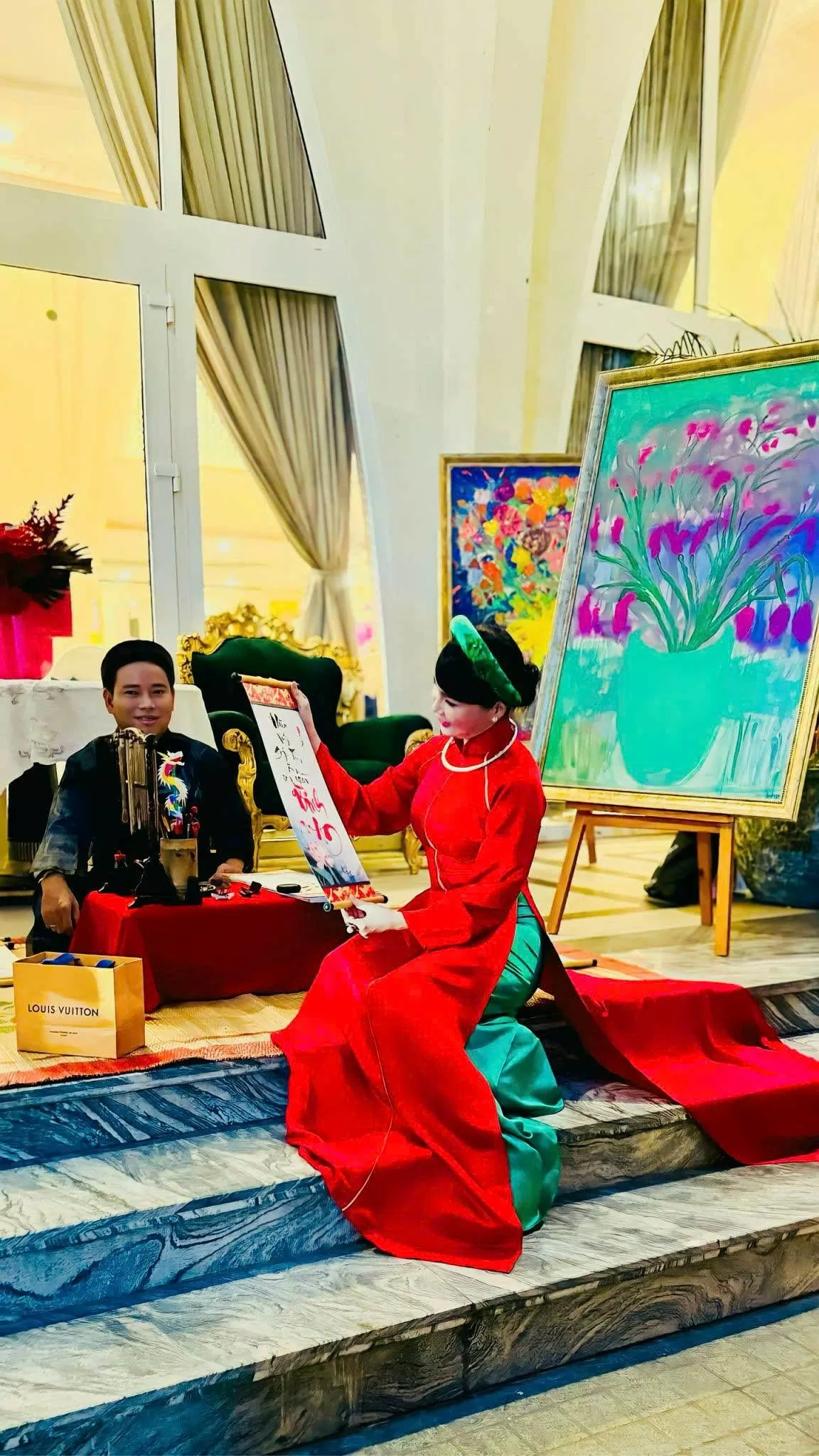 Ngày Xuân đi hội ông Đồ… cũng là một bộ áo dài đỏ mang không khí hội hè, chút hồng đỏ may mắn hanh thông, nhưng với tà áo hiện đại, điểm chút cách điệu ở cổ và vai, thân áo ôm trọn đường cong cơ thể, nàng đã sẵn sàng cùng chị em xuống phố xin chữ ông Đồ đ