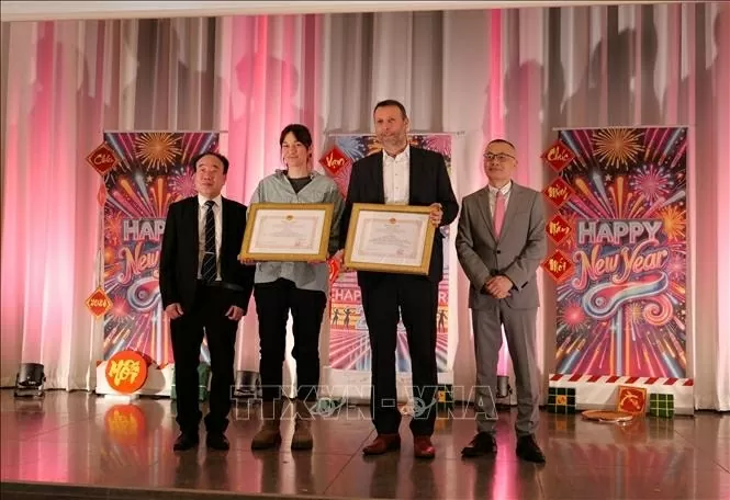 Đại sứ Vũ Quang Minh (ngoài cùng bên phải) tặng bằng khen cho ông Sebastian Kratsch (thứ hai từ phải), Trưởng phòng Dịch vụ Doanh nghiệp thuộc Văn phòng Phát triển Kinh tế thành phố Leipzig và bà Gabriel Goldfuß, Trưởng phòng hợp tác quốc tế thành phố Leipzig vì đã có nhiều đóng góp cho sự hợp tác toàn diện của thành phố Leipzig với Việt Nam. Ảnh: Phương Hoa - Pv TTXVN tại Đức