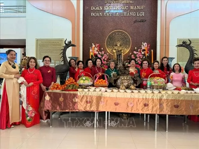 Những phụ nữ gốc Việt quây quần bên mâm cơm mùng 1 Tết Ất Tỵ dâng cúng Bác. (Ảnh: TTXVN