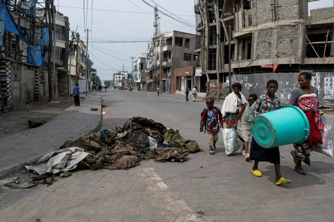 Người dân nhìn những bộ quân phục và thiết bị quân sự bị bỏ lại trên đường phố Goma trong bối cảnh xung đột giữa nhóm vũ trang M23 và Lực lượng vũ trang CHDC Congo (FARDC), tại Goma, miền Đông quốc gia châu Phi này, ngày 29/1. (Nguồn: Reuters)
