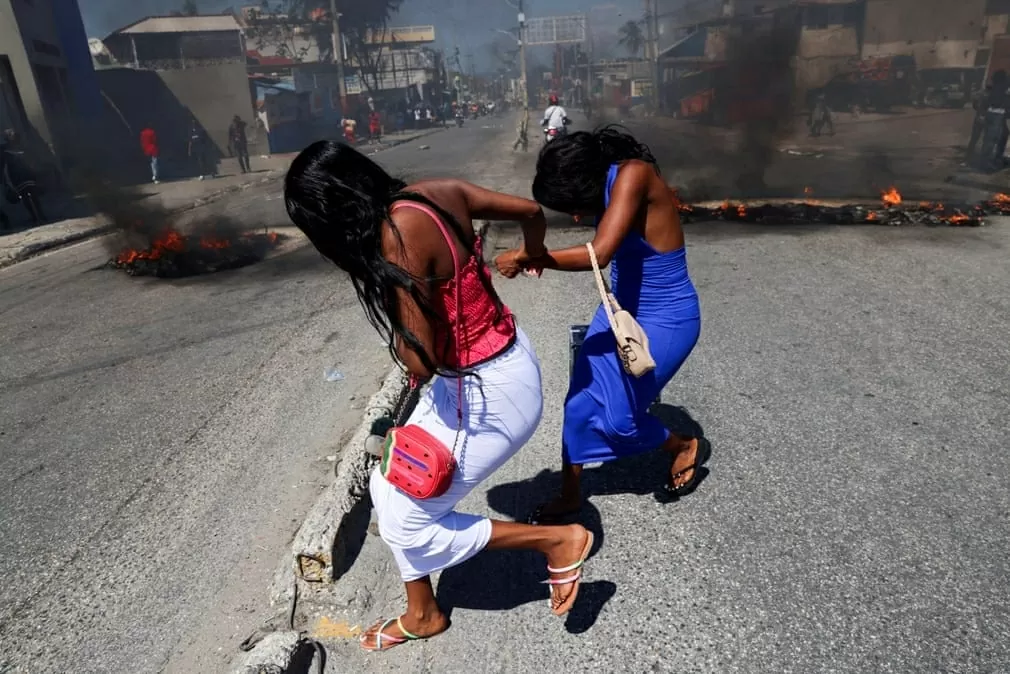 Những người phụ nữ chạy qua các rào chắn đường phố đang bốc cháy ở quận Solino, thủ đô Port-au-Prince, Haiti khi người dân biểu tình kêu gọi chính phủ giúp đỡ và phản đối tình trạng thiếu an ninh. (Nguồn: Reuters) Những người phụ nữ chạy qua các rào chắn đường phố đang bốc cháy ở quận Solino, thủ đô Port-au-Prince, Haiti khi người dân biểu tình kêu gọi chính phủ giúp đỡ và phản đối tình trạng thiếu an ninh. (Nguồn: Reuters)
