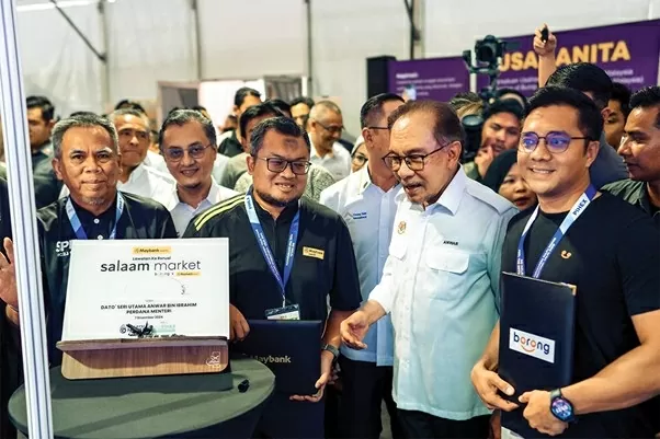 Ngày 7/12/2024, tại Triển lãm Quốc tế Halal Penang (PIHEX), Thủ tướng Malaysia Dato’ Seri Anwar Ibrahim (áo trắng phía trước) cùng Tiến sĩ Ramadhan đã tham dự lễ ra mắt Salaam Market, một nền tảng thương mại Halal mới nhằm thúc đẩy ngành công nghiệp Halal tại Malaysia. (Nguồn: The Edge Malaysia) Ngày 7/12/2024, tại Triển lãm Quốc tế Halal Penang (PIHEX), Thủ tướng Malaysia Dato’ Seri Anwar Ibrahim (áo trắng phía trước) cùng Tiến sĩ Ramadhan đã tham dự lễ ra mắt Salaam Market, một nền tảng thương mại Halal mới nhằm thúc đẩy ngành công nghiệp Halal tại Malaysia. (Nguồn: The Edge Malaysia)