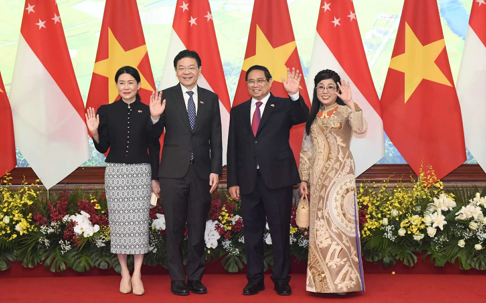 Thủ tướng Chính phủ Phạm Minh Chính và Phu nhân cùng Thủ tướng Lawrence Wong và Phu nhân tại lễ đón chính thức ngày 26/3. (Nguồn: NDO)
