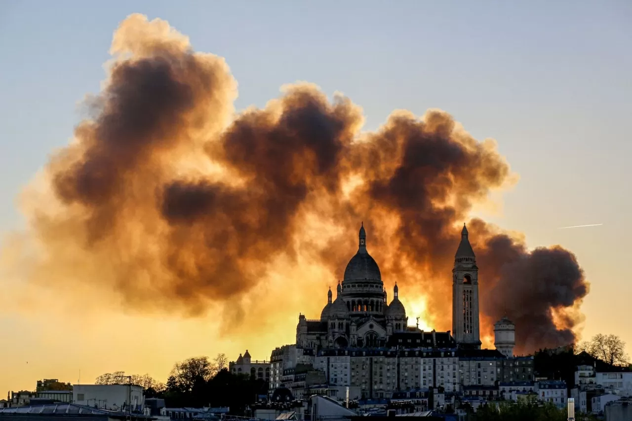 Khói bốc lên mù mịt phía sau Vương cung thánh đường Sacré-Cœur ở Paris khi một vụ hỏa hoạn lớn xảy ra tại quận 17 lân cận vào thứ Hai, ngày 7 tháng 4. (Nguồn: Getty)