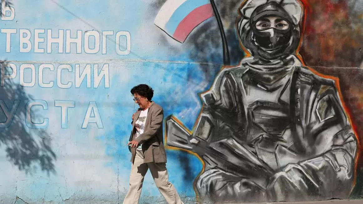 Washington cân nhắc vấn đề về Crimea trong nỗ lực chấm dứt xung đột Nga-Ukraine, ông Trump muốn hoàn tất nhanh chóng. Một người phụ nữ đi ngang qua bức tranh tường mô tả một người lính cầm cờ Nga ở Simferopol, Crimea, vào ngày 2 tháng 10 năm 2024. (Nguồn: Reuters)