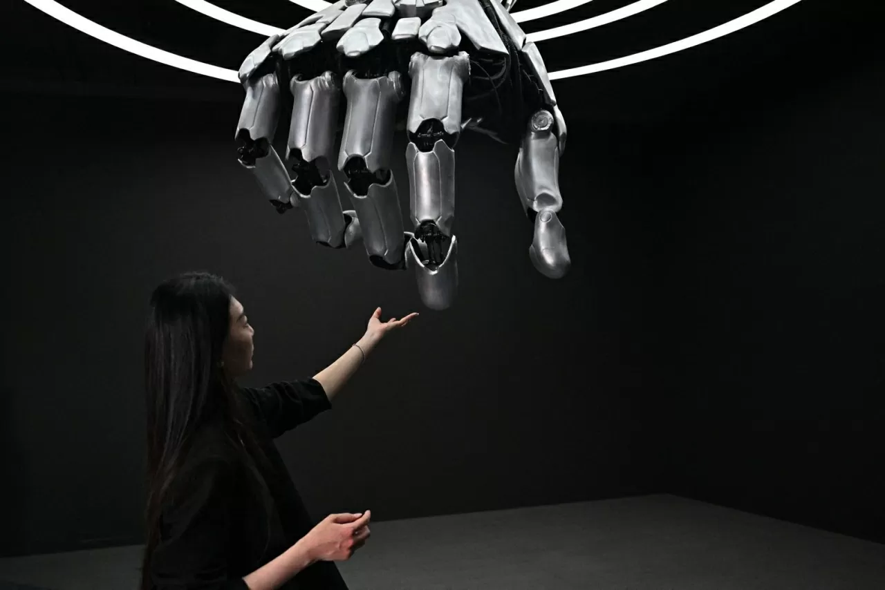 Một người phụ nữ chạm vào cánh tay robot trong chuyến tham quan dành cho báo chí tại Triển lãm thế giới Robot ở Bắc Kinh, ngày 17/4. (Nguồn: AFP)