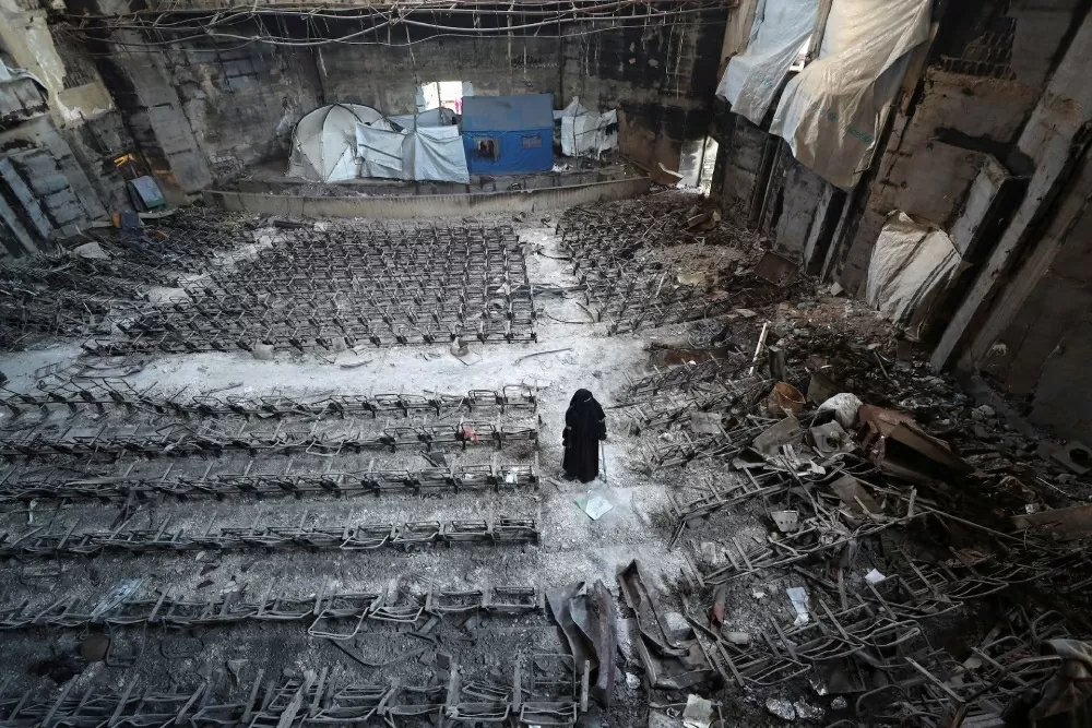 Cô Mervat Al-Bassiouny, một phụ nữ Palestine bị mất chân do một cuộc không kích của Israel, đang nhìn những thiệt hại bên trong một tòa nhà tại Đại học Hồi giáo Gaza, nơi cô đã tốt nghiệp. Nơi này đã trở thành mục tiêu tấn công trong các cuộc không kích ngày 11/4 của Tel Aviv tại thành phố Gaza City. (Nguồn: Reuters)