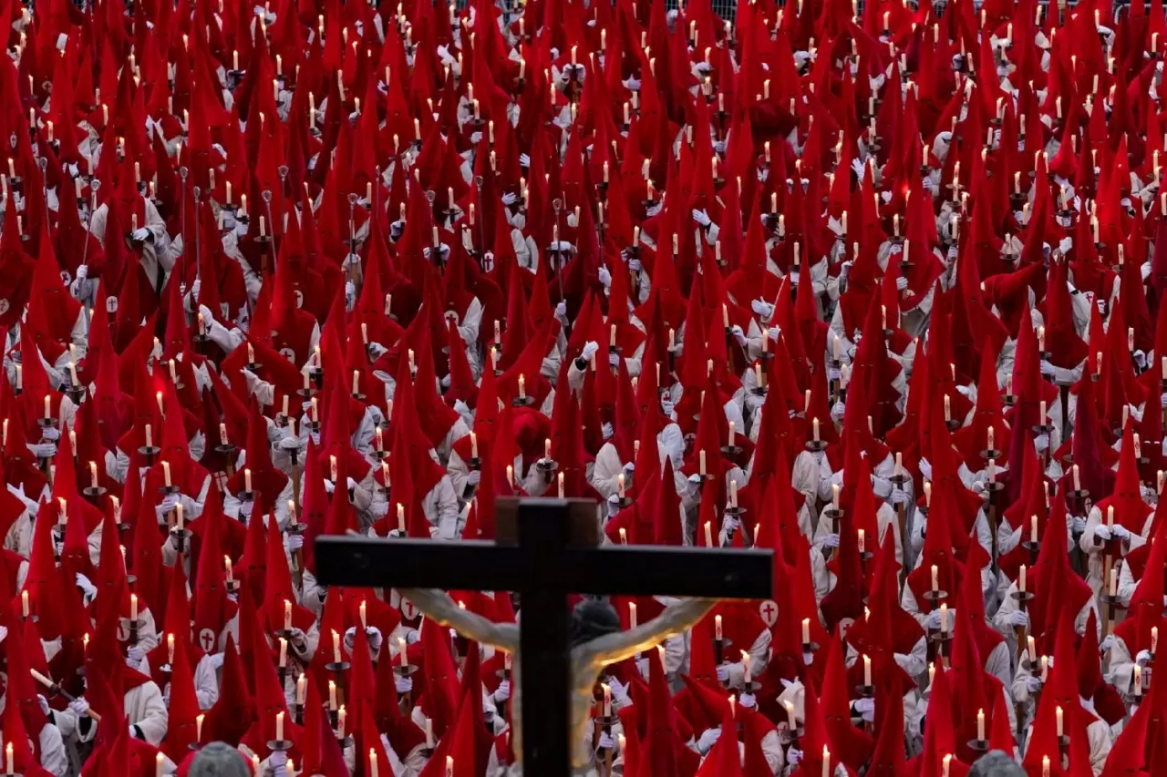 Các thành viên của hội anh em Real Hermandad del Santísimo Cristo de las Injurias quỳ gối trước khi tham gia cuộc rước im lặng tại Zamora. (Nguồn: AFP)