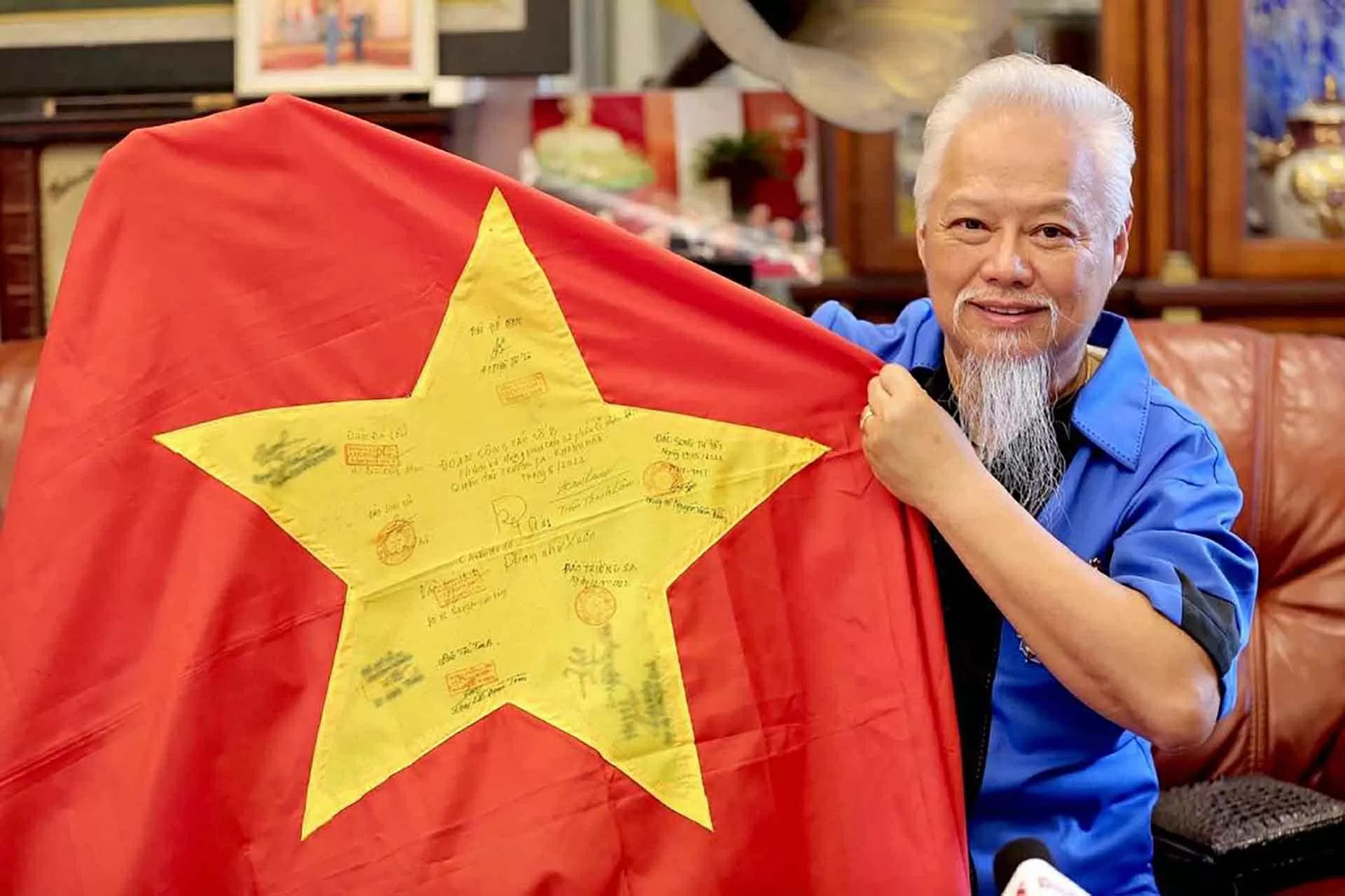 Ông David Nguyễn với lá cờ Tổ quốc đã được lấy chữ ký và đánh dấu tại quần đảo Trường Sa. (Ảnh NVCC)