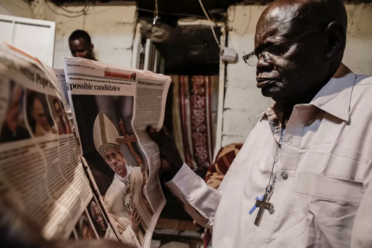 Một người đàn ông đọc tin tức về Đức Giáo hoàng tại nhà mình ở Nairobi, Kenya. (Nguồn: Getty)